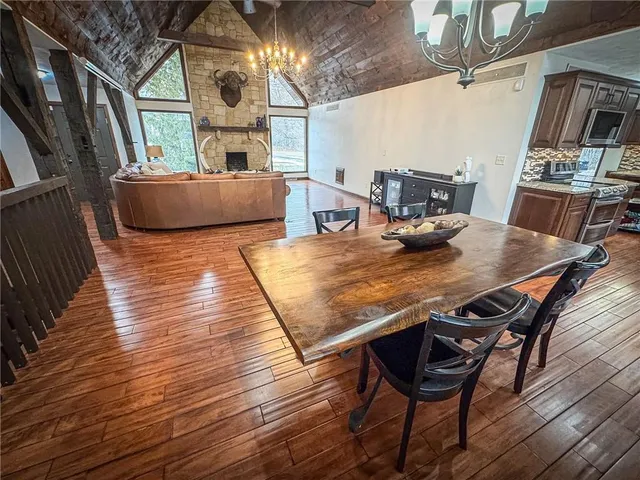 a living room with a table chairs and kitchen view