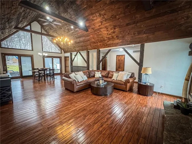 a living room with furniture floor to ceiling window and wooden floor