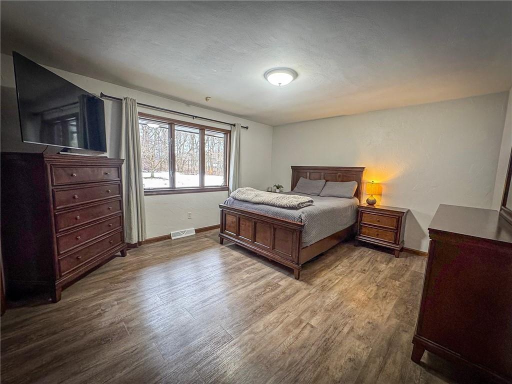 706 Clearfield Road Fenelton, PA 16034 - Photo 25 of 50 a spacious bedroom with a bed and wooden floor
