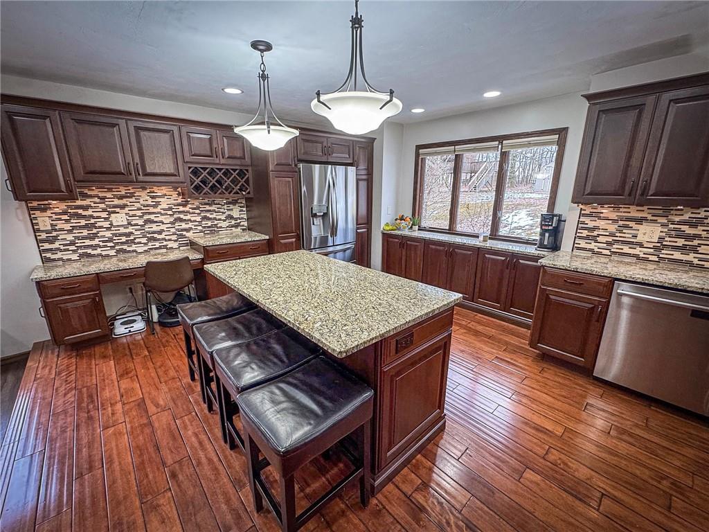 706 Clearfield Road Fenelton, PA 16034 - Photo 4 of 50 a kitchen with stainless steel appliances granite countertop a stove top oven a refrigerator a sink dishwasher and a dining table with wooden floor