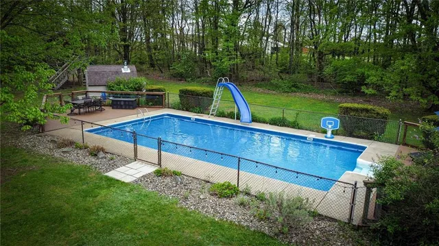 a view of a swimming pool with a table and chairs under an umbrella