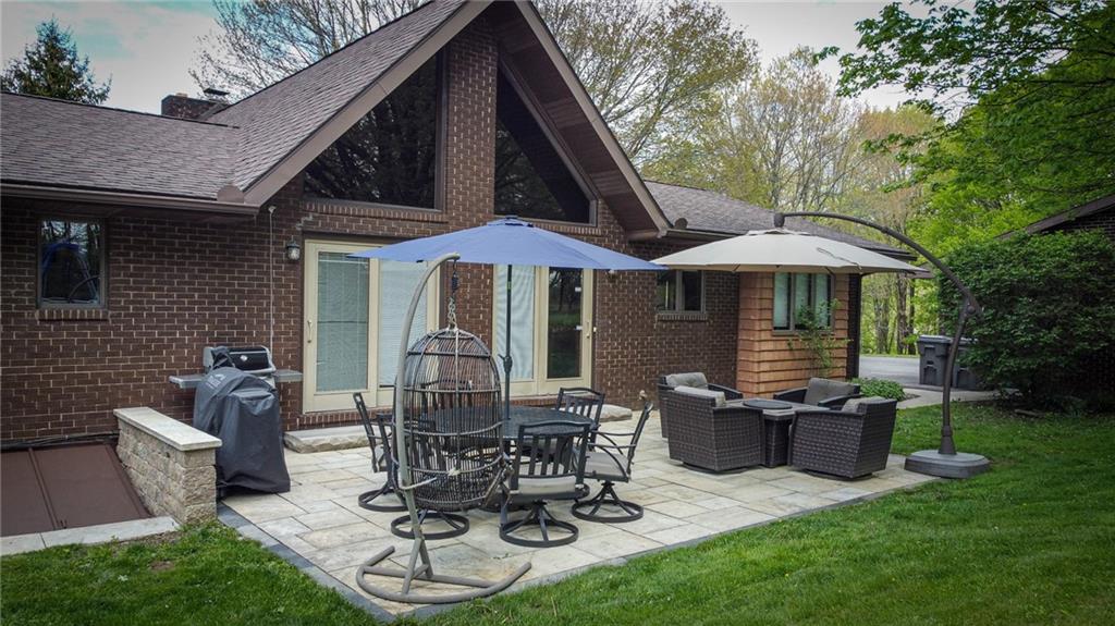 706 Clearfield Road Fenelton, PA 16034 - Photo 49 of 50 a view of a patio with table and chairs under an umbrella with a barbeque grill and plants