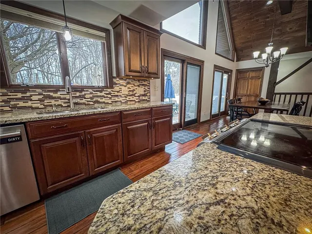a kitchen with stainless steel appliances granite countertop a sink stove and cabinets