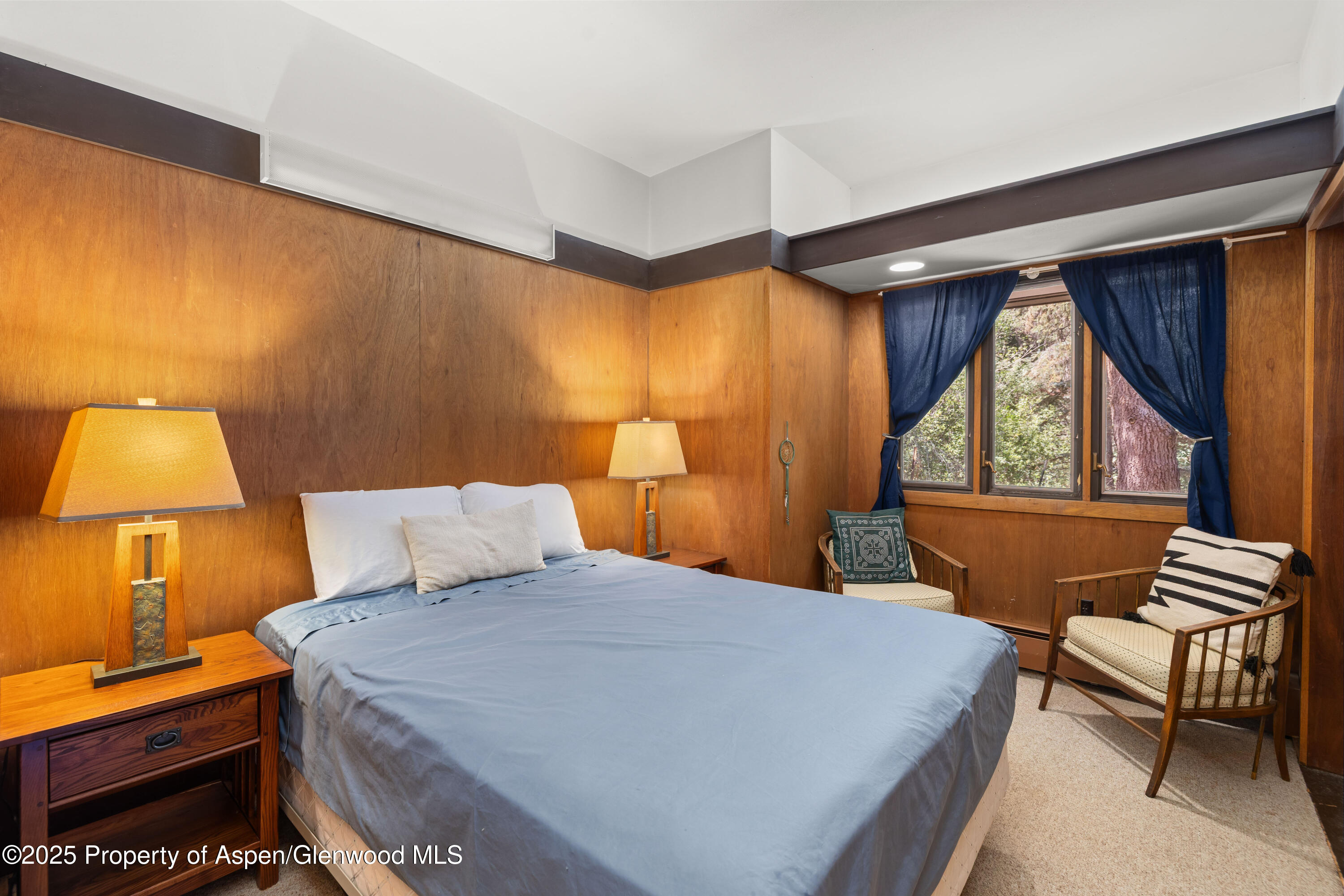 820 Twining Flats Road Aspen, CO 81611 - Photo 6 of 15 a bedroom with a bed and a lamp next to a window