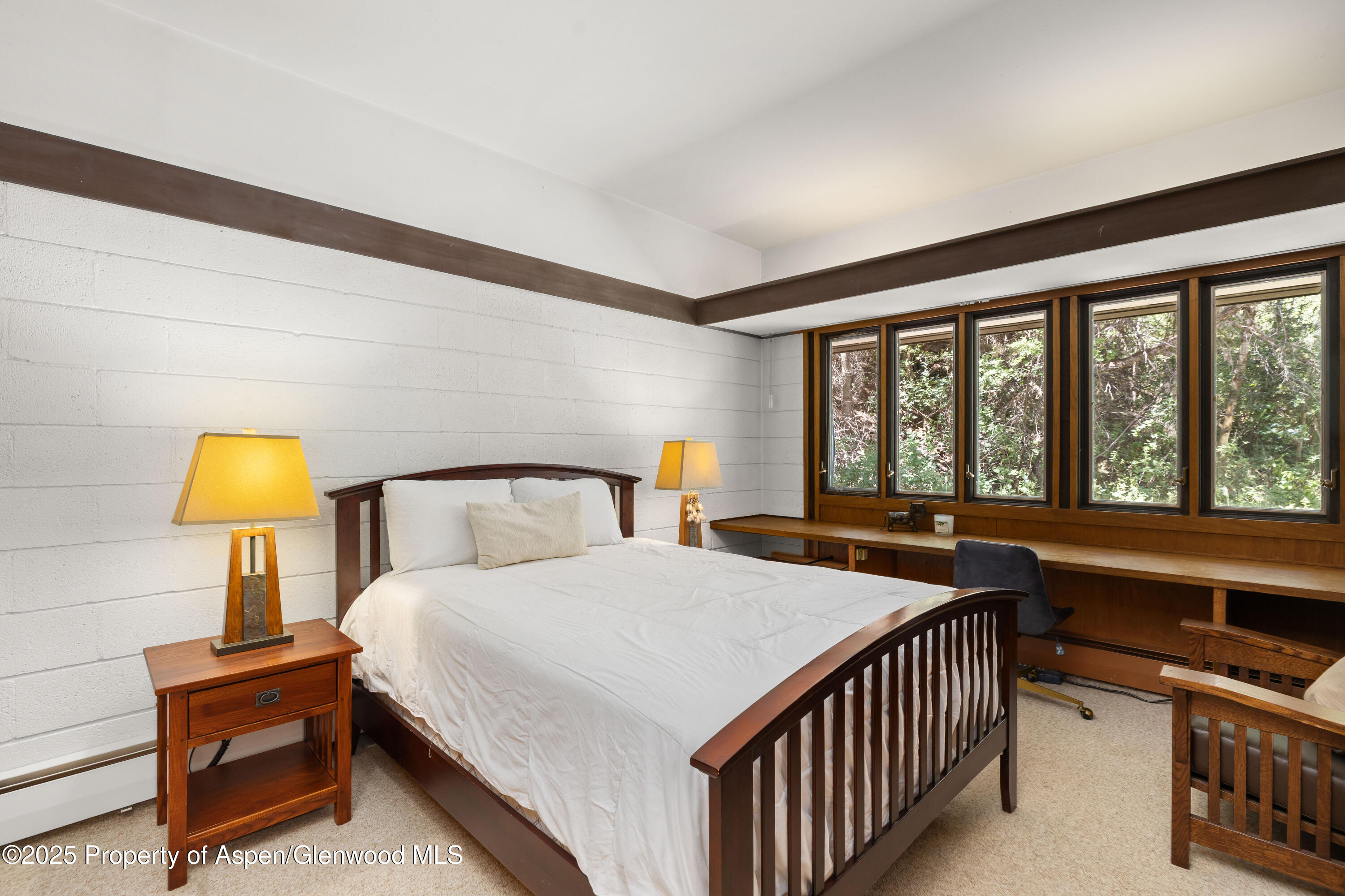 820 Twining Flats Road Aspen, CO 81611 - Photo 7 of 15 a bedroom with a bed a lamp and a large window with outer view