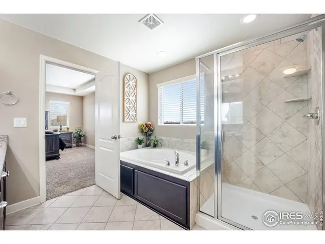 a bathroom with a tub sink shower and mirror