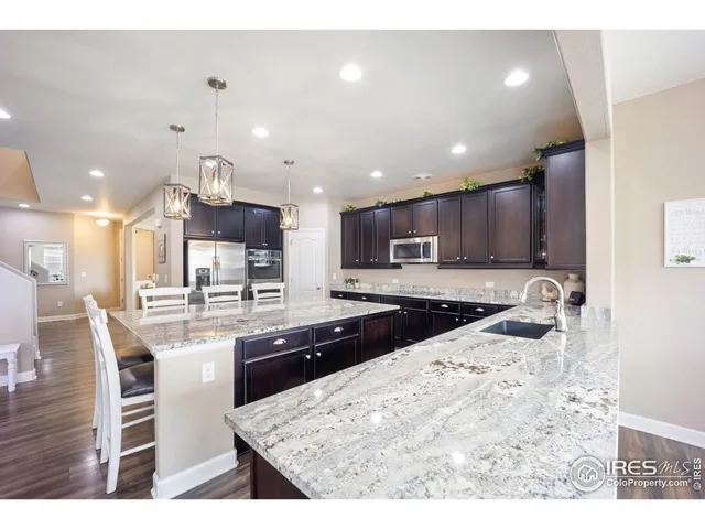a kitchen with stainless steel appliances kitchen island granite countertop a sink and cabinets
