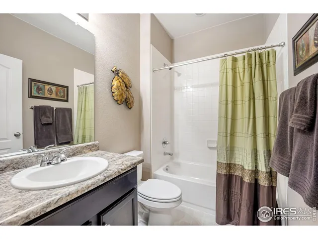 a bathroom with a granite countertop sink toilet a mirror and shower