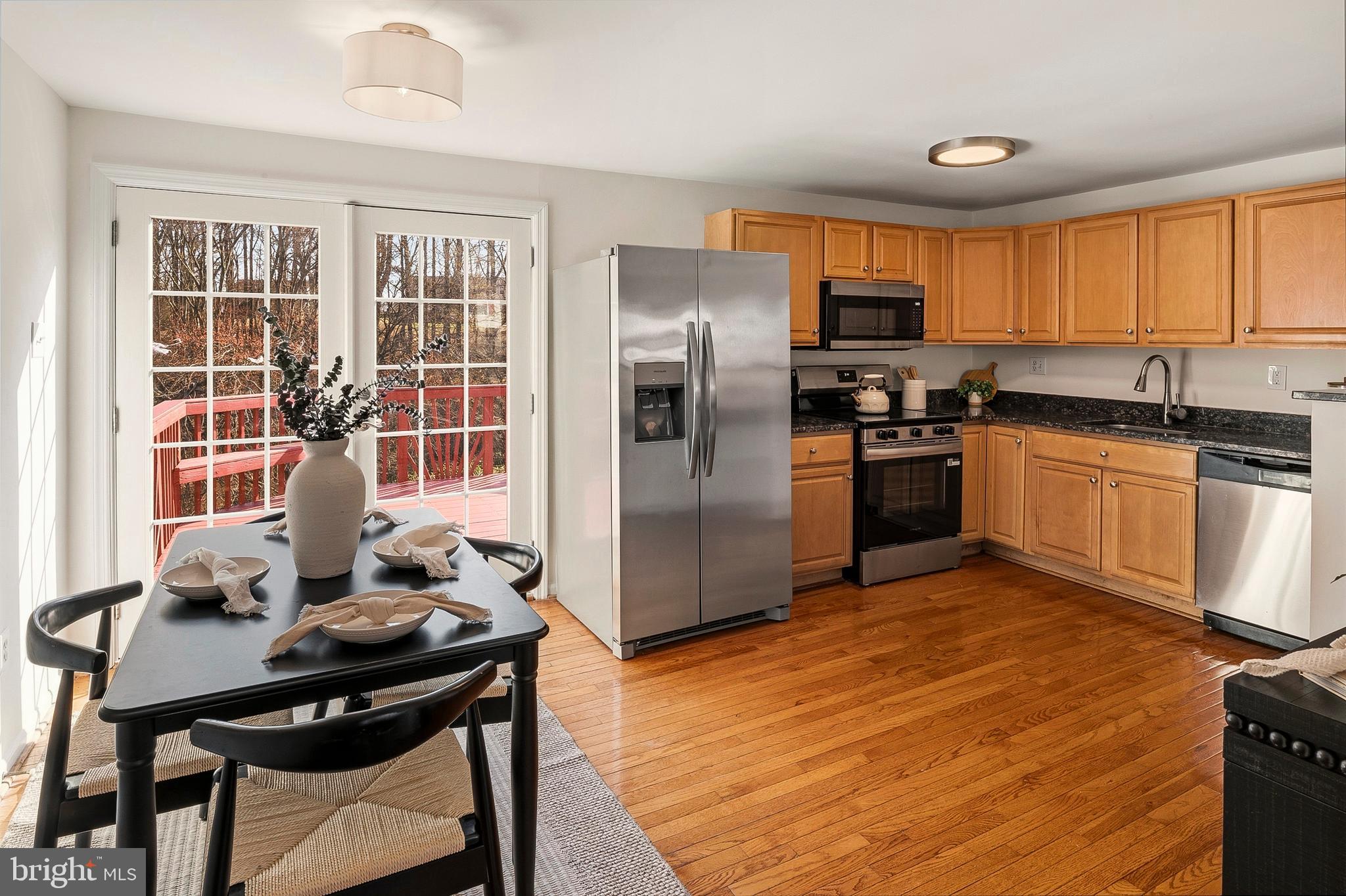 3617 Ripplingbrook Court Bowie, MD 20721 - Photo 6 of 29 a kitchen with stainless steel appliances granite countertop a stove a refrigerator a sink a dining table and chairs with wooden floor