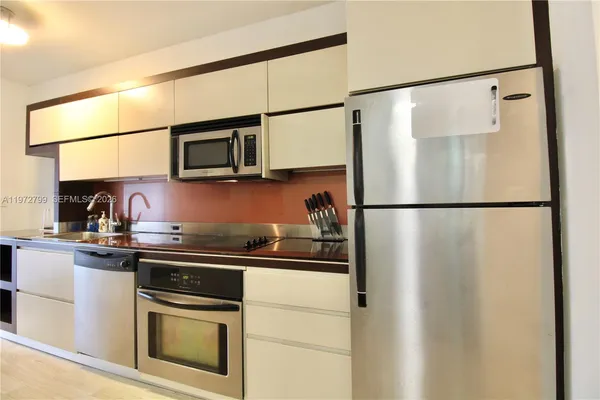 a kitchen with stainless steel appliances granite countertop a refrigerator and a sink