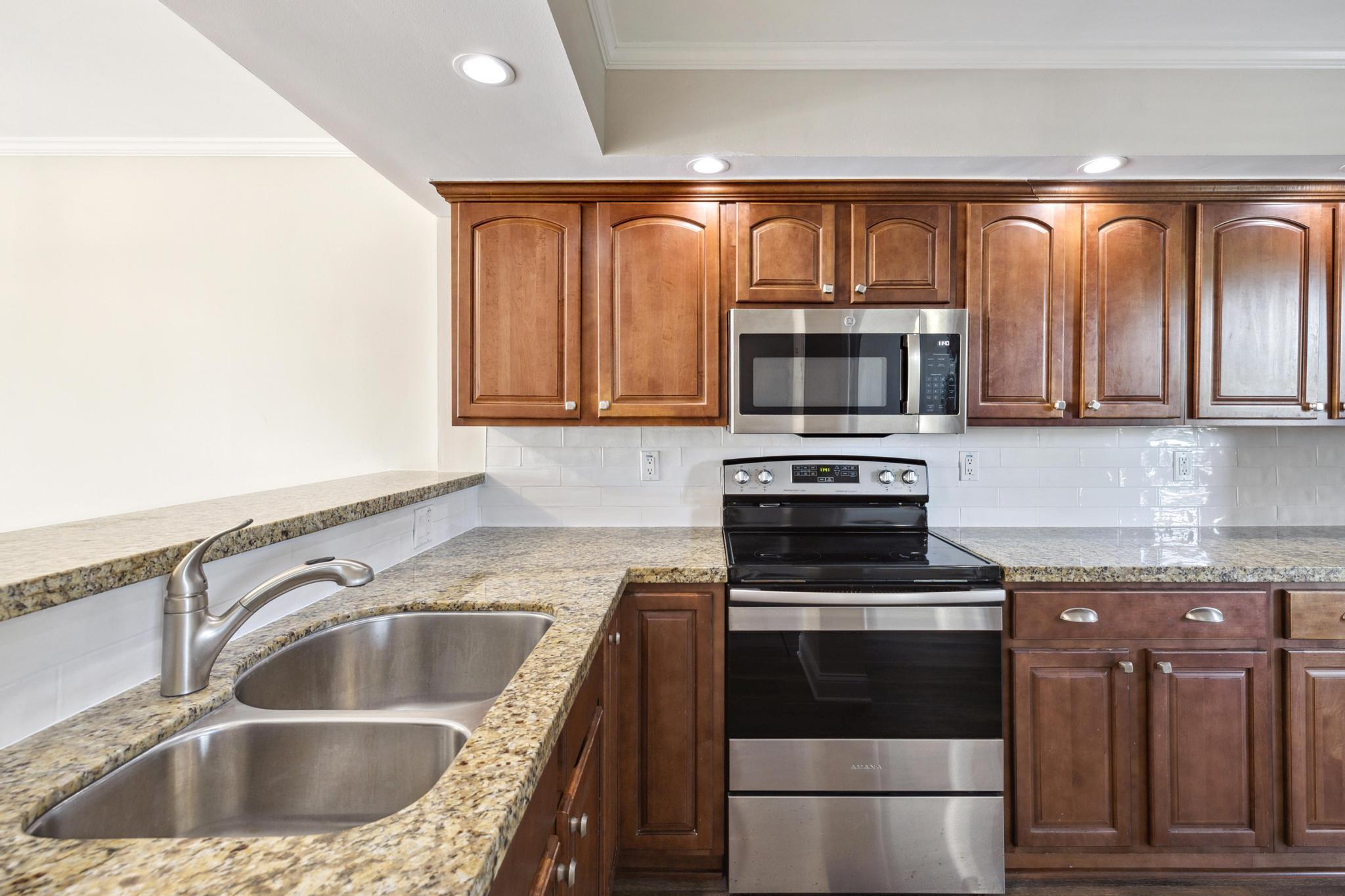 4 Royal Palm Way, Unit 2080 Boca Raton, FL 33432 - Photo 5 of 23 a kitchen with granite countertop a sink and a stove top oven