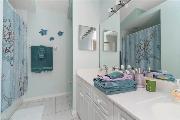 a bathroom with a granite countertop sink a mirror and shower