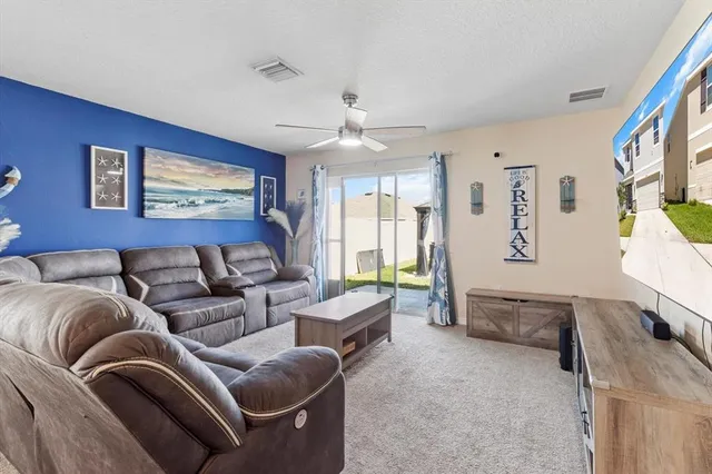 a living room with furniture two window and a flat screen tv