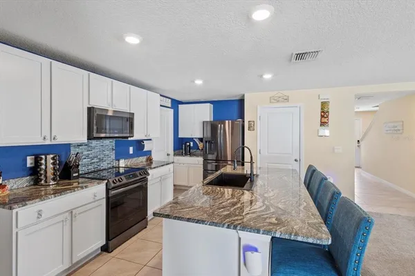 a kitchen with stainless steel appliances granite countertop a sink refrigerator and microwave