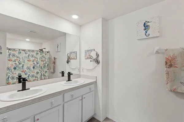 a bed room with a bed and a chandelier fan