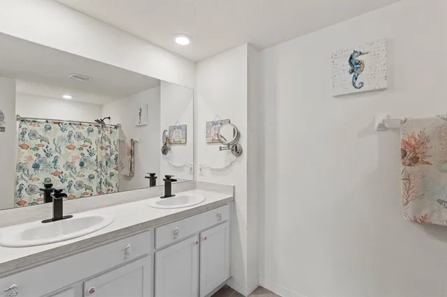 a bed room with a bed and a chandelier fan