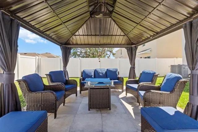 a front view of building with glass windows and outdoor seating