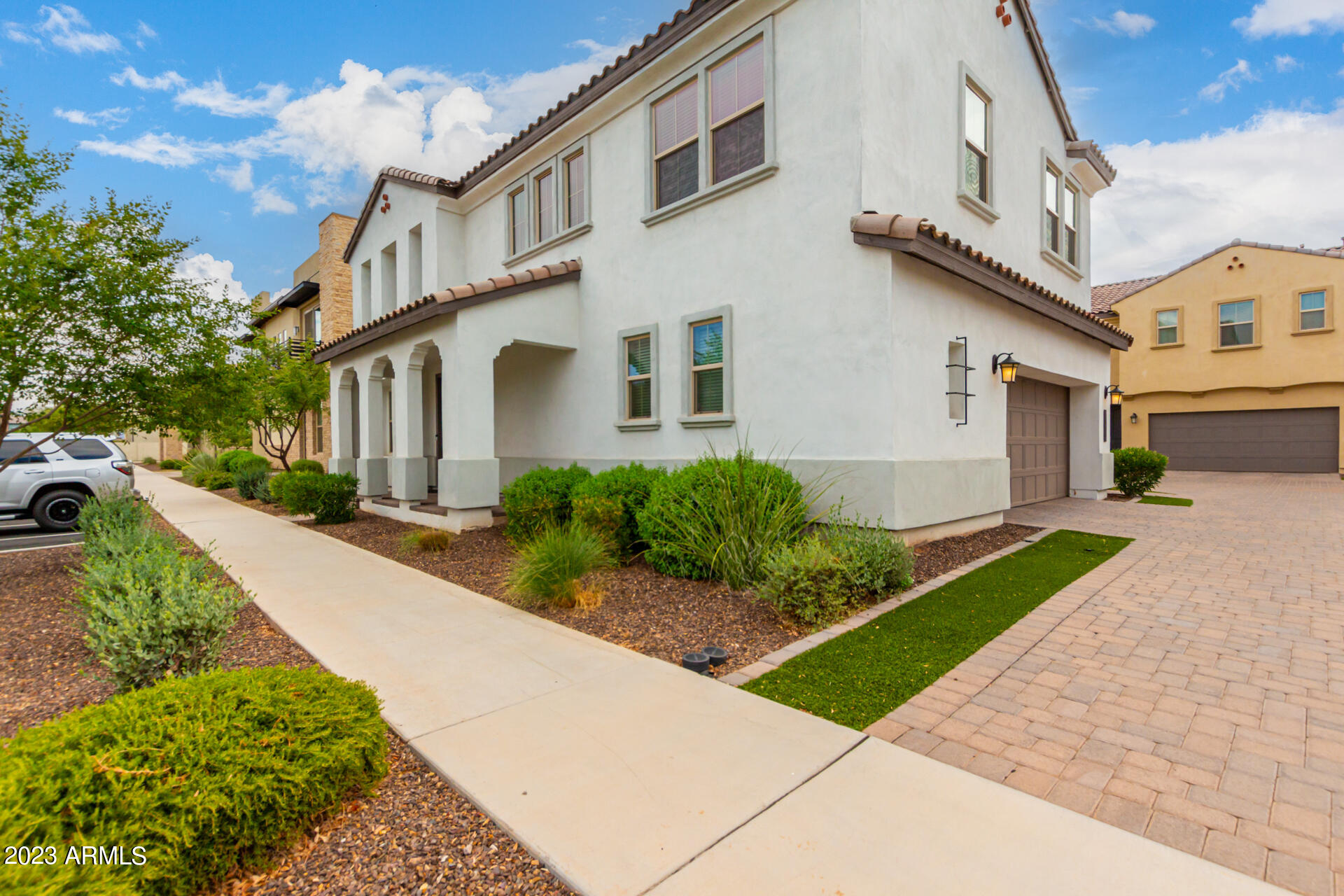 a front view of a house with a yard and potted plants