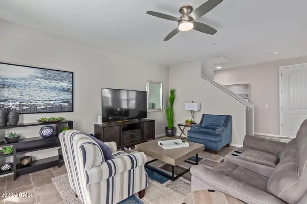 a living room with furniture a ceiling fan and a window