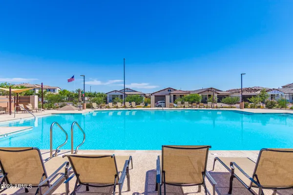 a view of a chairs and table in patio with swimming pool