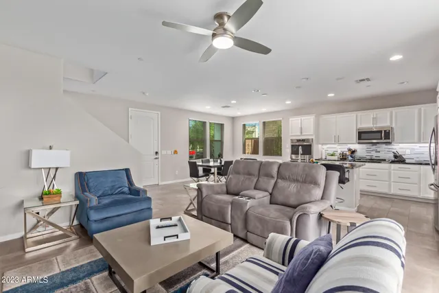 a living room with furniture kitchen view and a chandelier