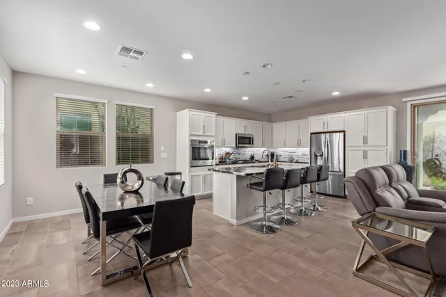 a dining room with furniture and view of kitchen