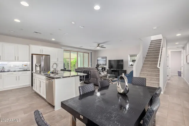 a kitchen with a stove a sink dishwasher a dining table and chairs with wooden floor