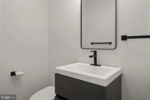 a bathroom with a sink a mirror and toilet