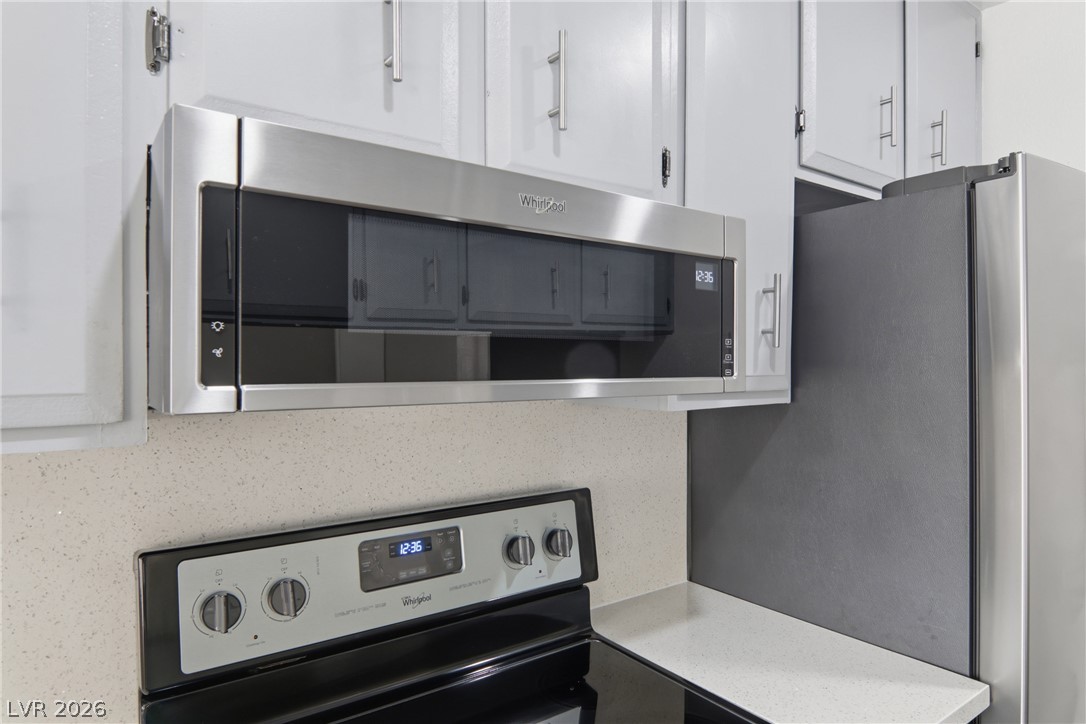 2274 East Desert Inn Road Las Vegas, NV 89169 - Photo 12 of 41 Culinary convenience unfolds with a stainless steel microwave and sleek electric range in this contemporary kitchen.