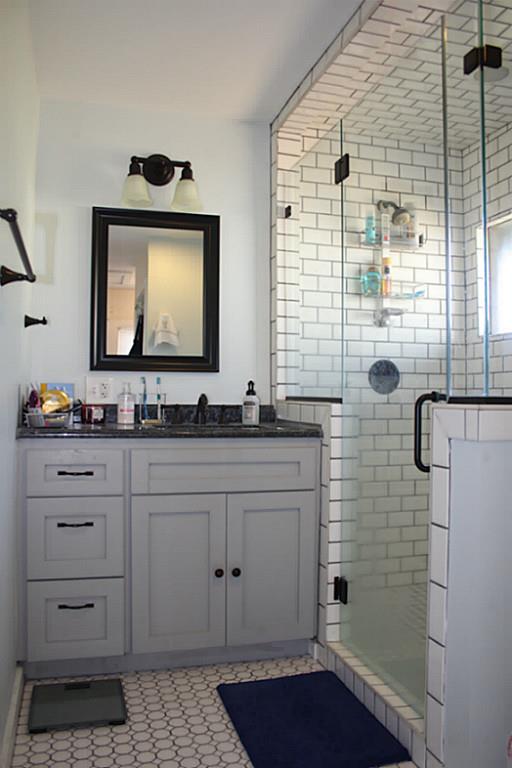 1609 1/2 Kipling Street Houston, TX 77006 - Photo 11 of 11 The master bath has a standing shower with subway tile surround, granite counter, and tile flooring.
