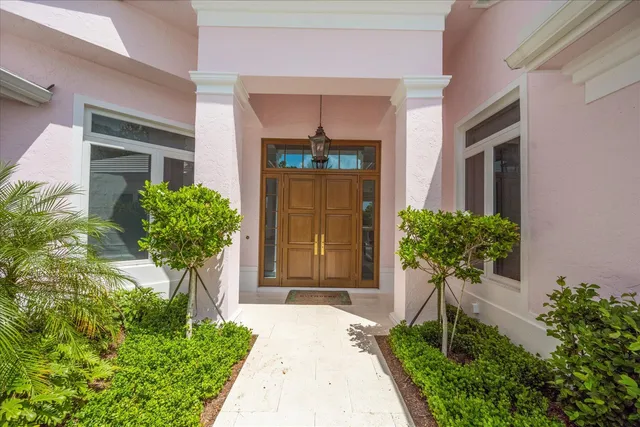 a front view of a house with a yard and potted plants