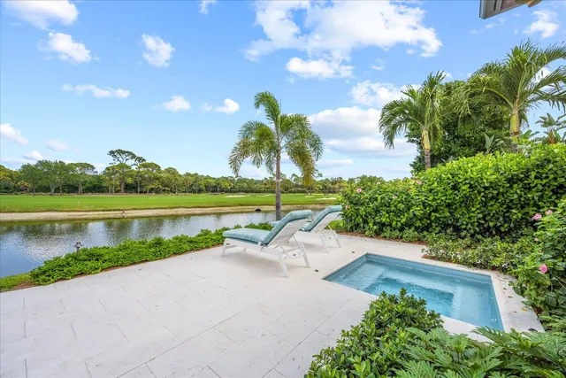 a view of a lake with a yard and potted plants