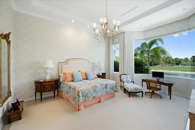 a bedroom with bed a flat tv screen and a large dresser with the garden view