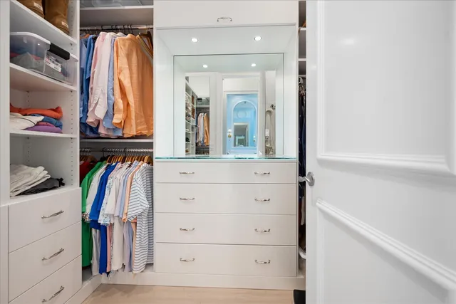 a view of walk in closet with clothes and shoes