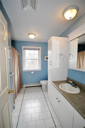 113 Acton Street Maynard, MA 01754 - Photo 15 of 20 a bathroom with a sink a mirror and a shower