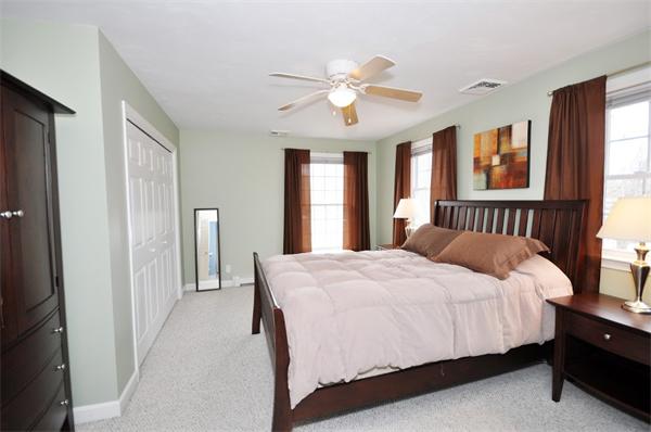 113 Acton Street Maynard, MA 01754 - Photo 17 of 20 a bedroom with a large bed and a chandelier