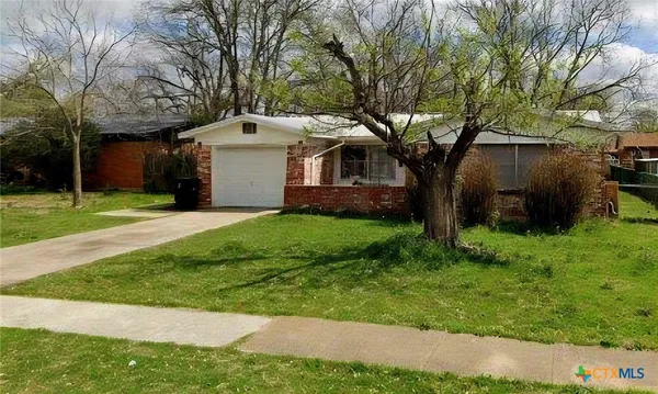 a front view of a house with a yard and trees