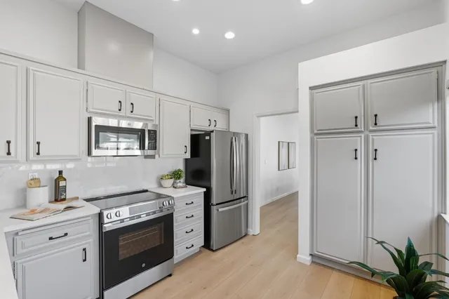 a kitchen with stainless steel appliances a refrigerator sink and stove