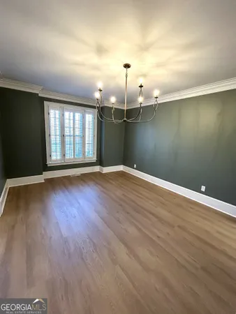 a view of a livingroom with wooden floor a ceiling fan and windows