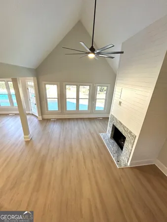 a large kitchen with stainless steel appliances granite countertop a stove a sink dishwasher a microwave oven and a dining table with wooden floor