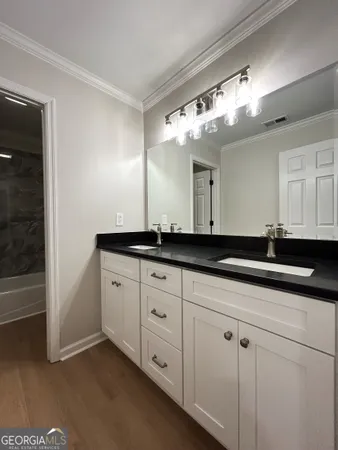 a view of a wooden house with a yard and lawn chairs