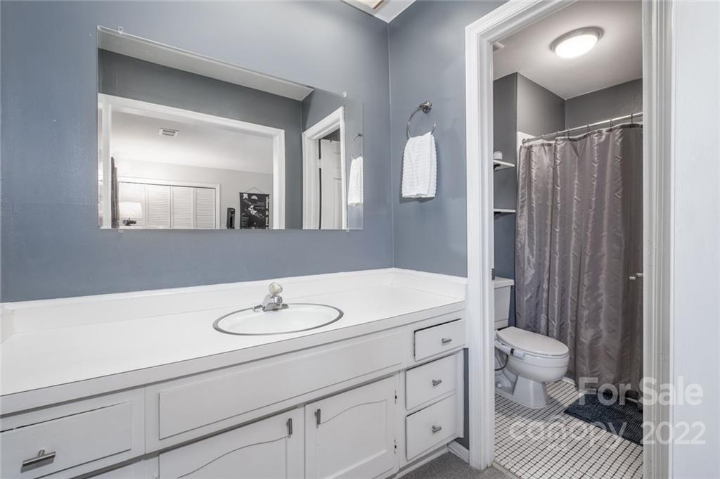 8346 Knights Bridge Road Charlotte, NC 28210 - Photo 12 of 29 a bathroom with a sink a toilet and a mirror