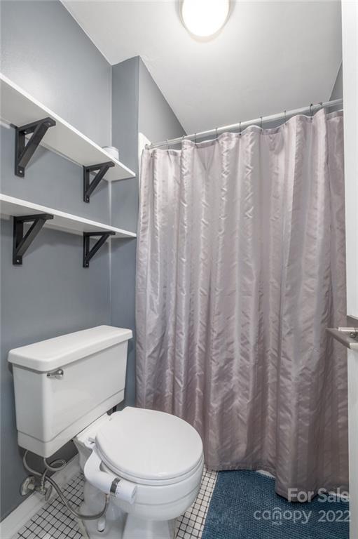 8346 Knights Bridge Road Charlotte, NC 28210 - Photo 13 of 29 a white toilet sitting next to a shower curtain