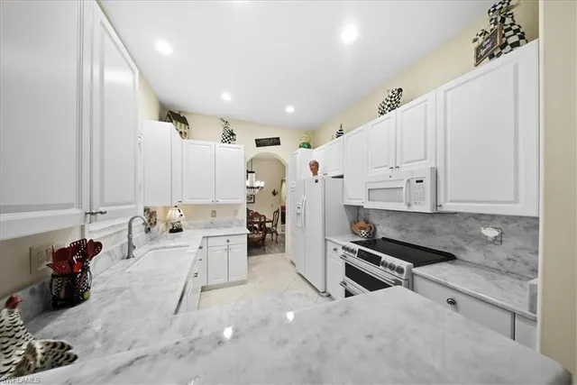 a large white kitchen with stainless steel appliances