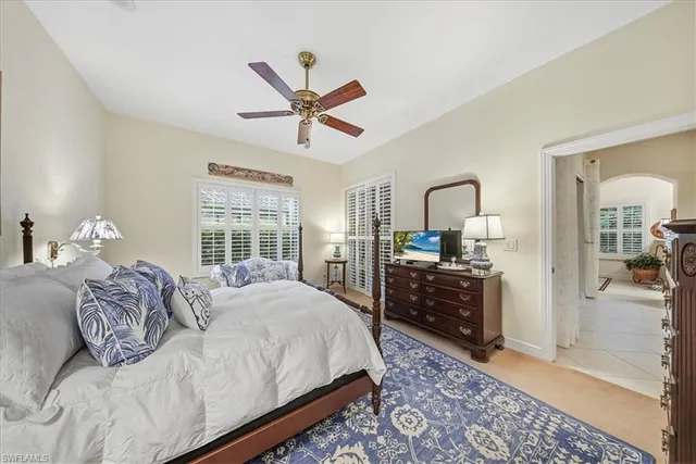 a spacious bedroom with a bed a dresser and potted plant