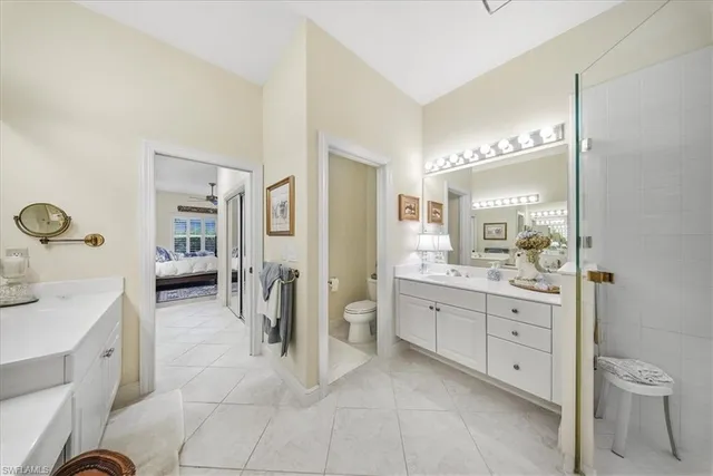 a spacious bathroom with a granite countertop sink a toilet and a mirror