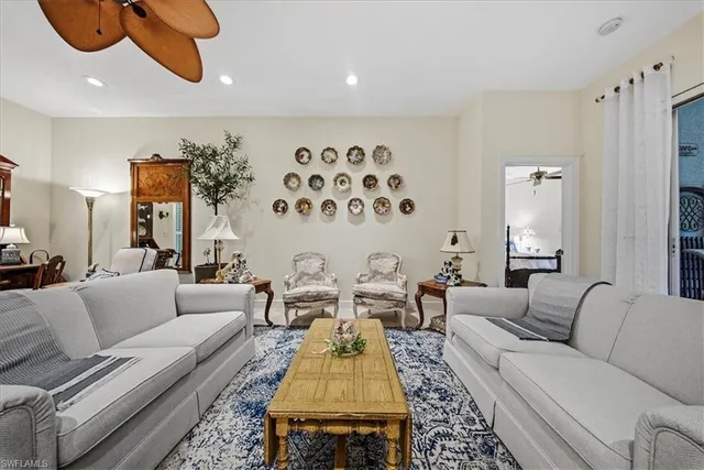 a living room with furniture ceiling fan and a rug