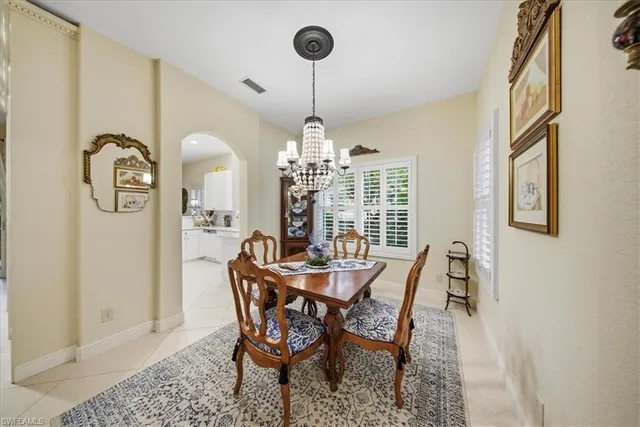 a dining room with furniture a chandelier and window