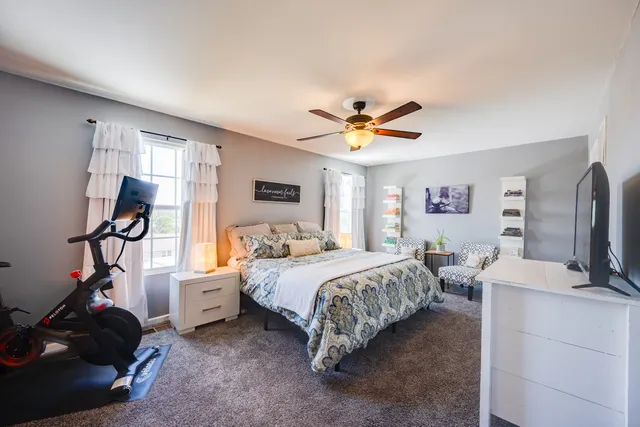 a bedroom with bed tv and a window