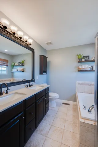 a spacious bathroom with a toilet sink and mirror